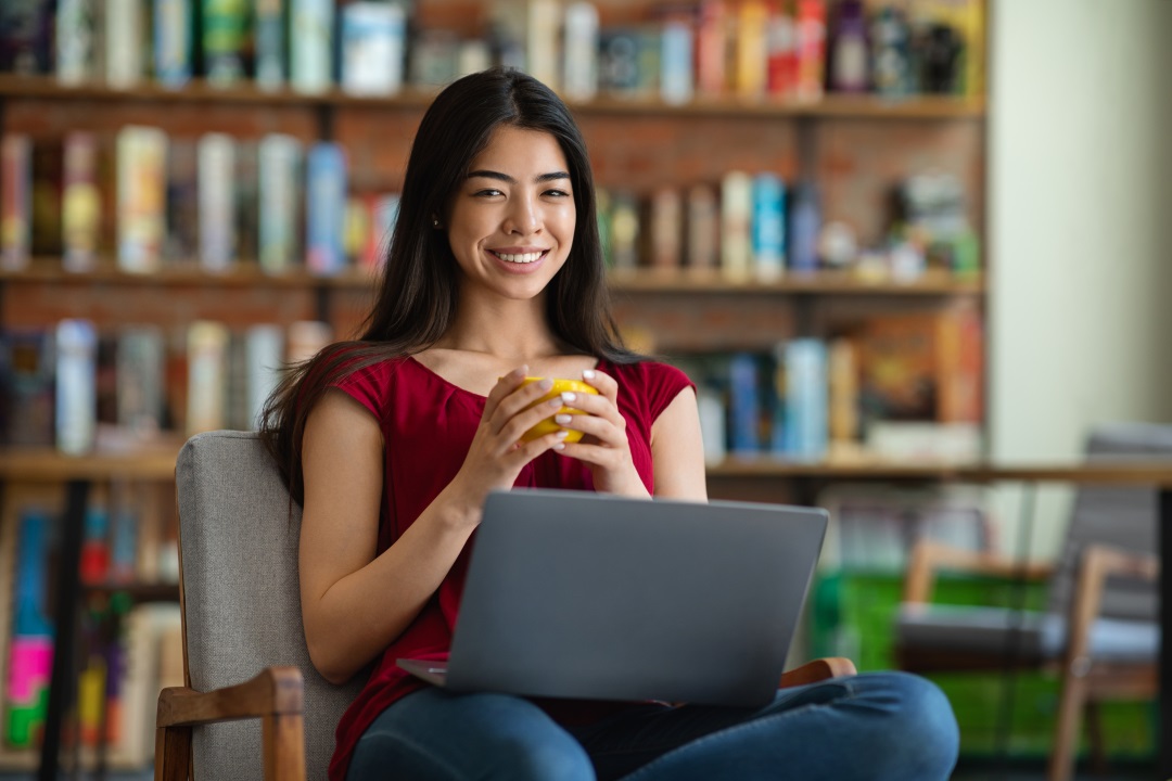 Estudiante mexicana con una taza en la mano y su laptop